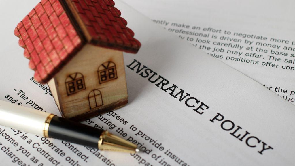 Home Insurance Policy Paperwork with a Model Home