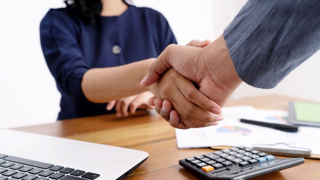 Business Partners Shaking Hands Over a Desk