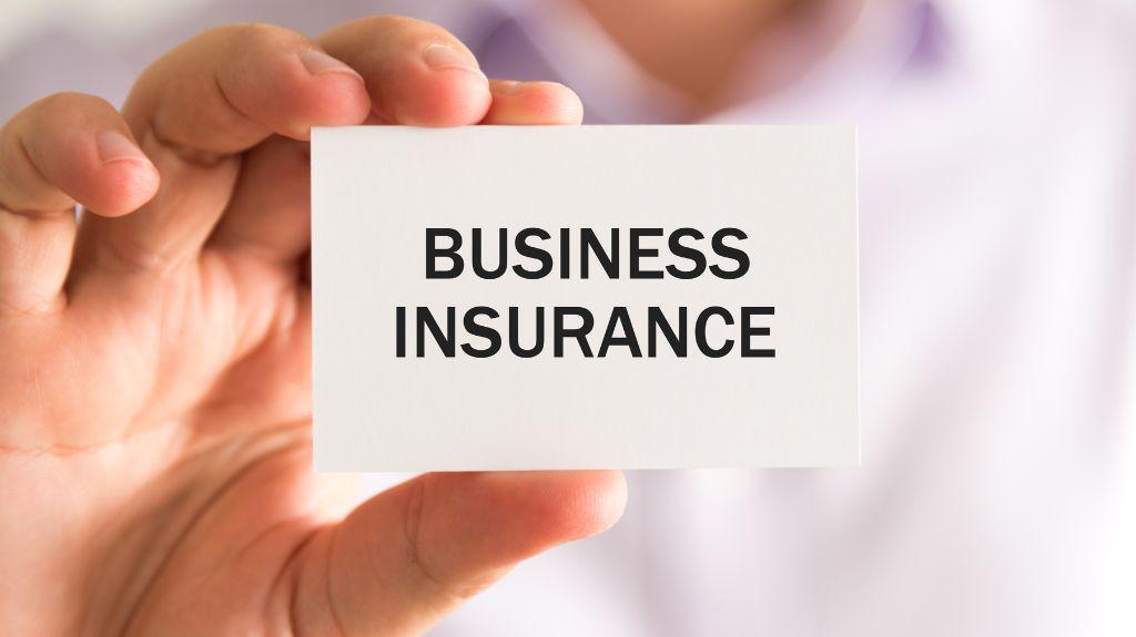 Person Holding White Business Card with Black Business Insurance Text