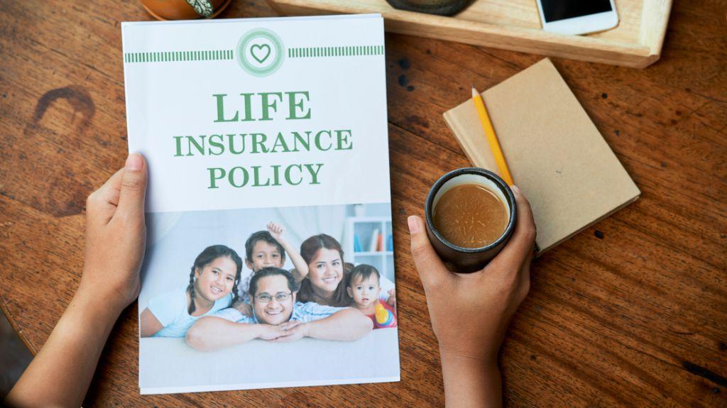 Person at a Desk with Coffee and Life Insurance Policy Folder