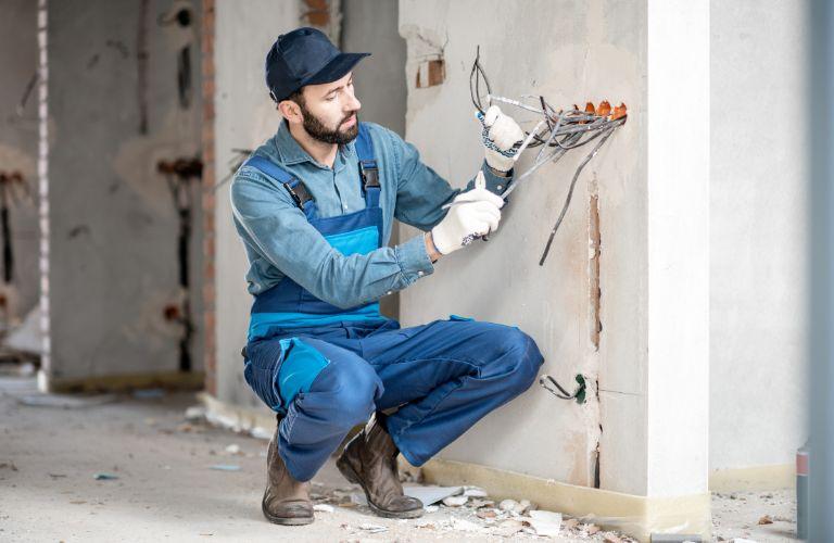 Electrician Repairing Wiring in a Building