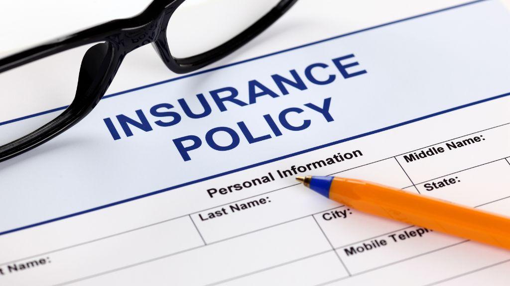 Insurance Policy Document with Pencil and Glasses