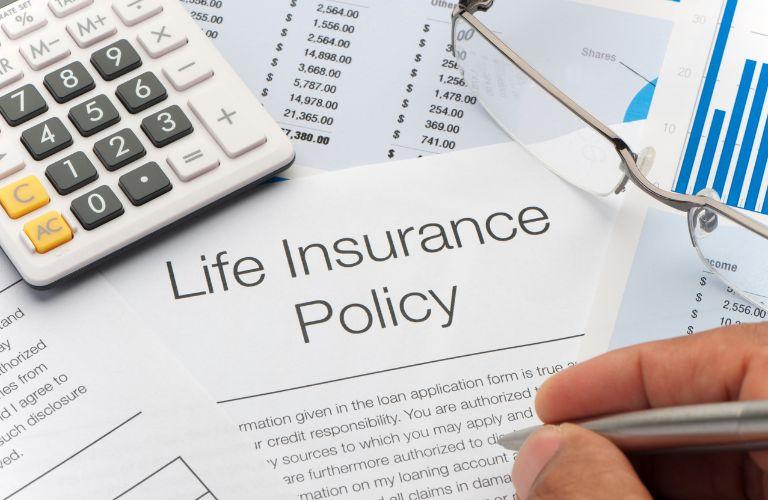 Person Filling Out Life Insurance Policy Paperwork