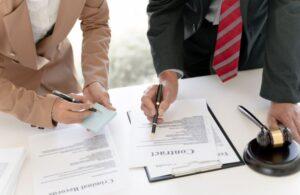 Lawyers Going Over Lawsuit Paperwork at a Desk with a Gavel