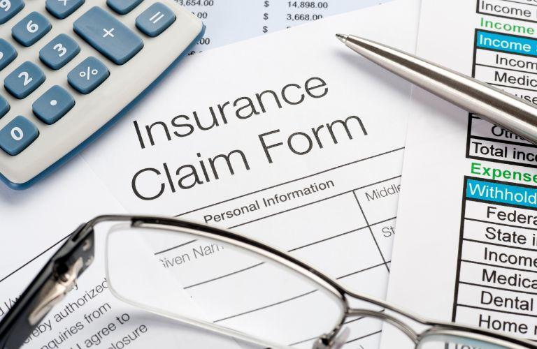 Insurance Claim Form with Calculator on a Desk