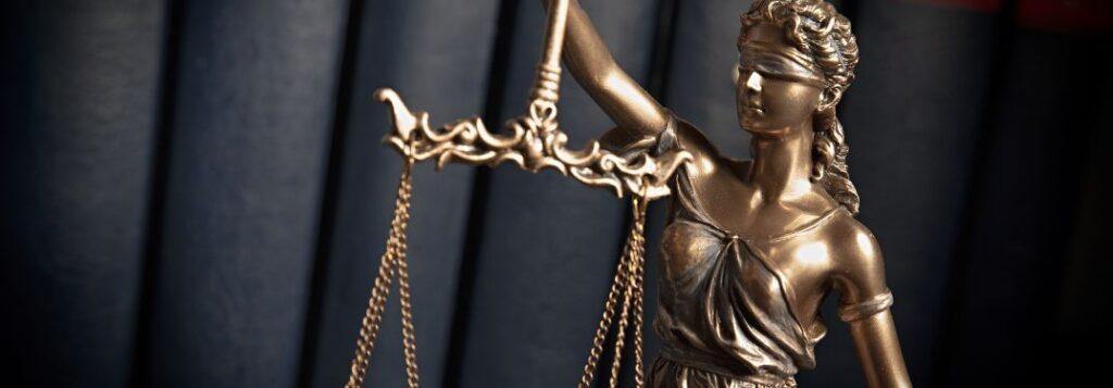 Blind lady justice in front of books