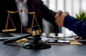 Shaking hands with scale and gavel