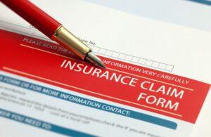 Red Pen with Insurance Claim Form Document