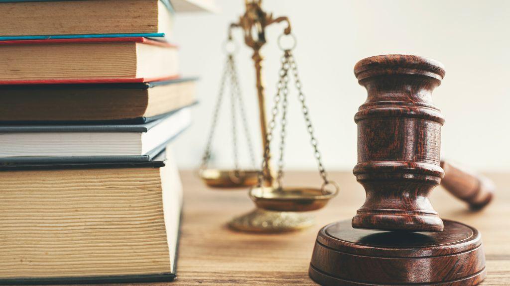 Stack of Books, Gavel and Scales on a Table