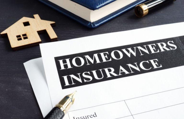 Homeowners Insurance Policy Form with Model Home on a Desk