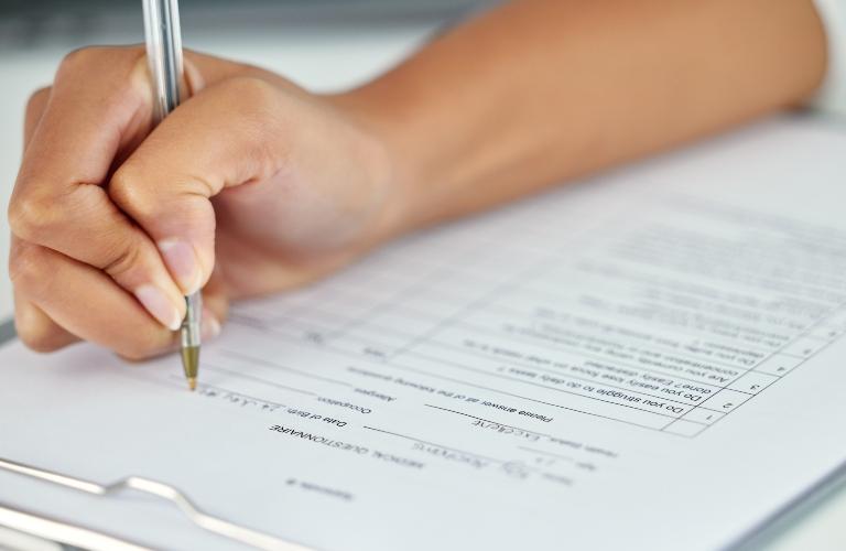 woman fills out documents to obtain insurance