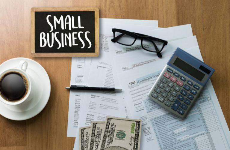 Small Business Sign, Calculator, Money and Documents on a Desk