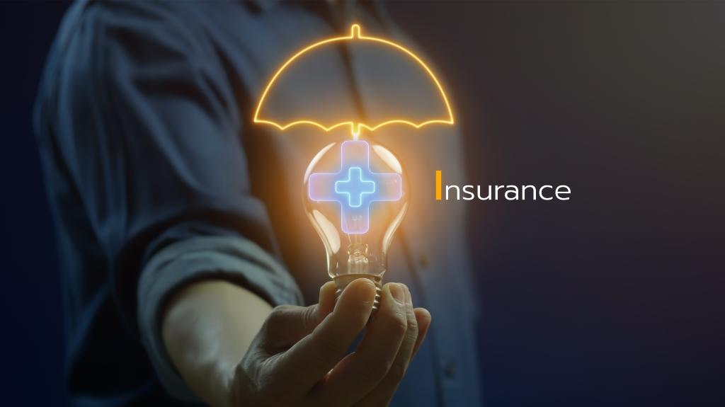 man holds a glowing light bulb with the word insurance in his hands